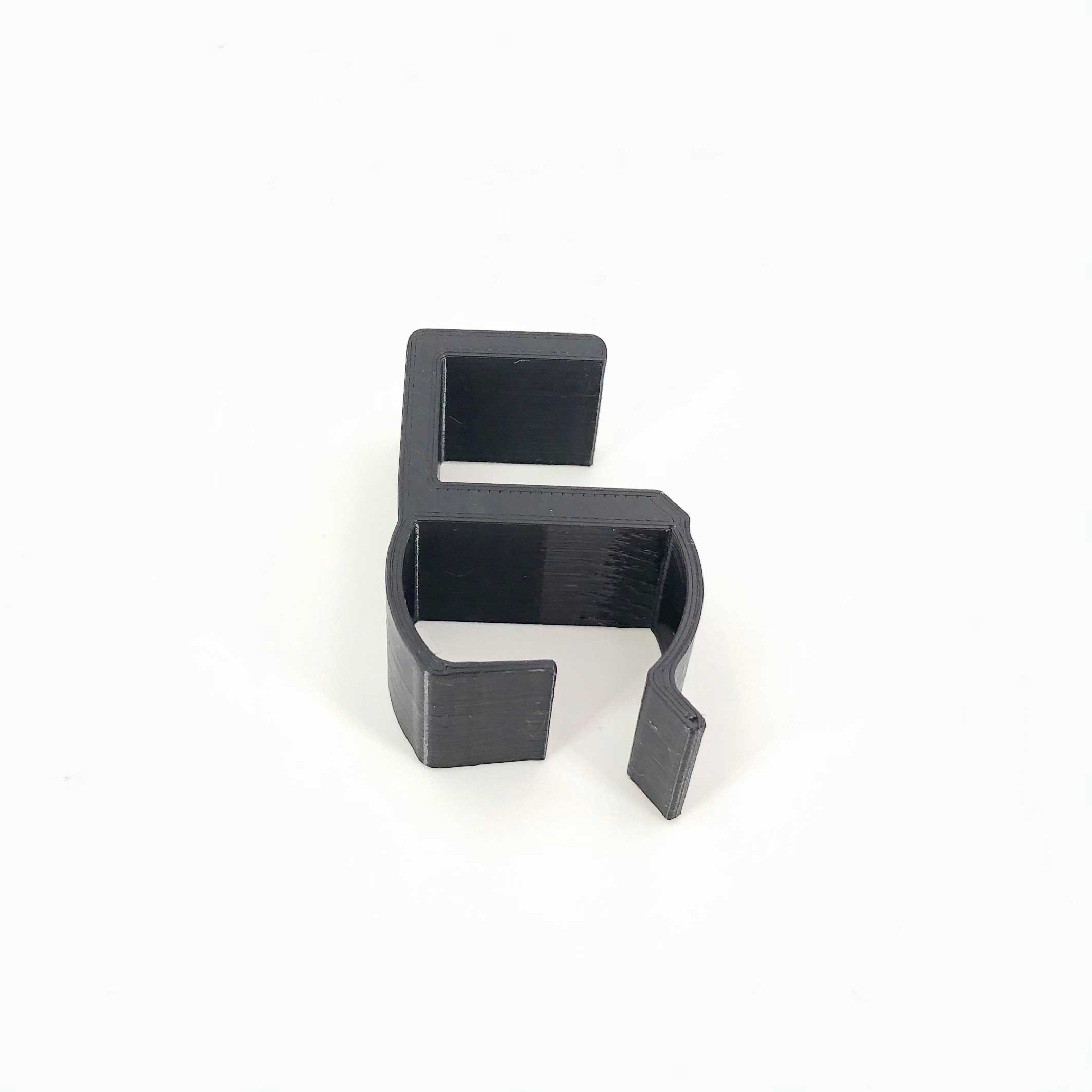 3D-utskriven kabelorganisator monterad på ett skrivbord tillverkad av PETG-filament i svart av en 3D-utskriftstjänst i Sverige